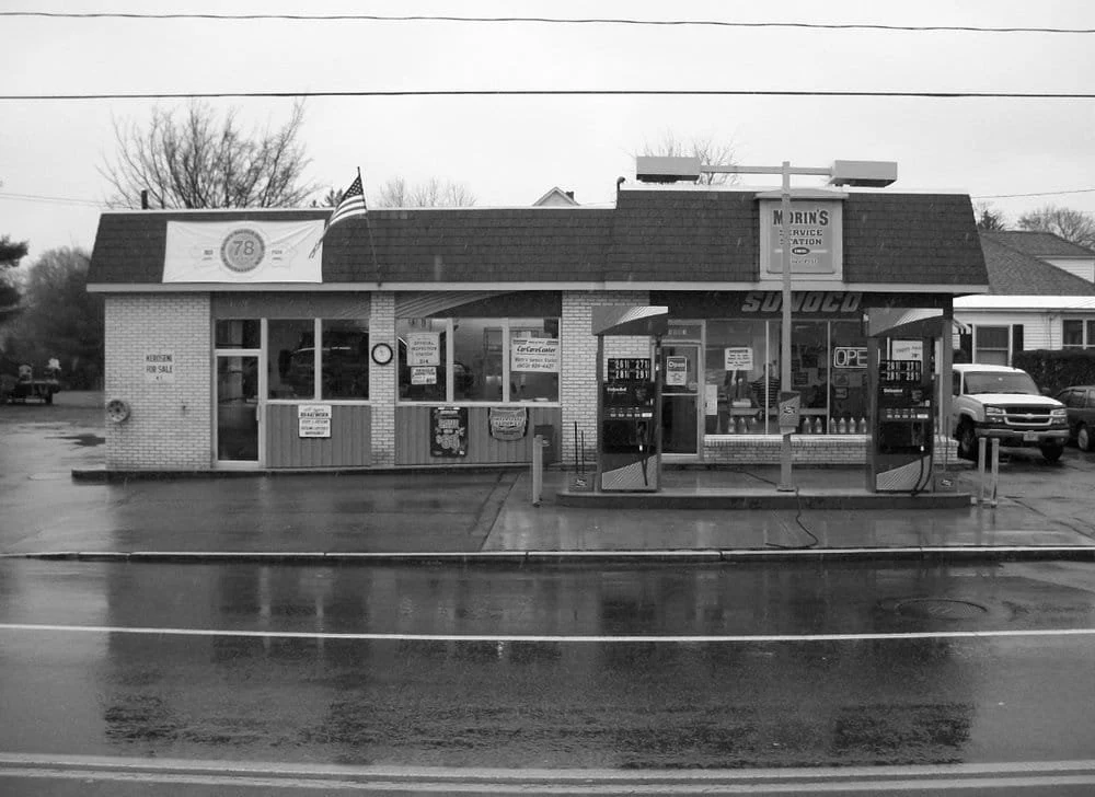 Morin’s Service Station on a rainy day, with its service bays and fuel pumps